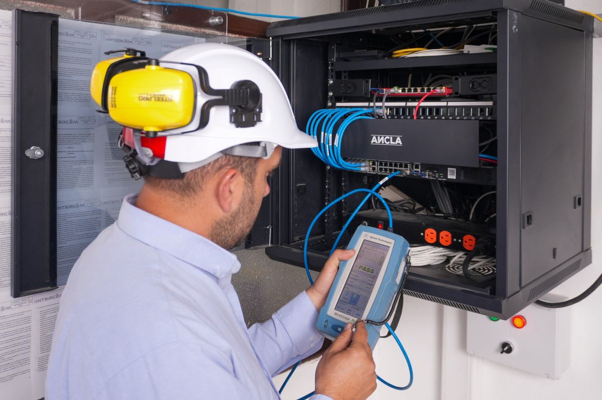 Técnico de INTERCOM TC certificando un punto de red en un rack de datos