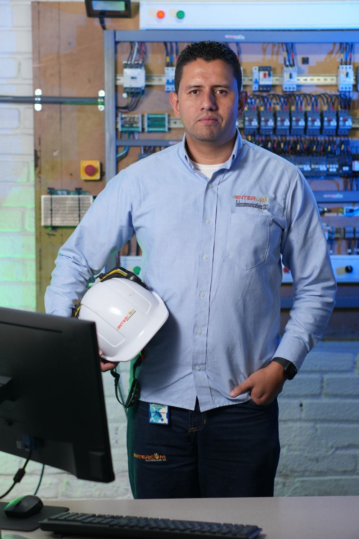 Técnico de INTERCOM TC con casco de seguridad frente a un tablero eléctrico