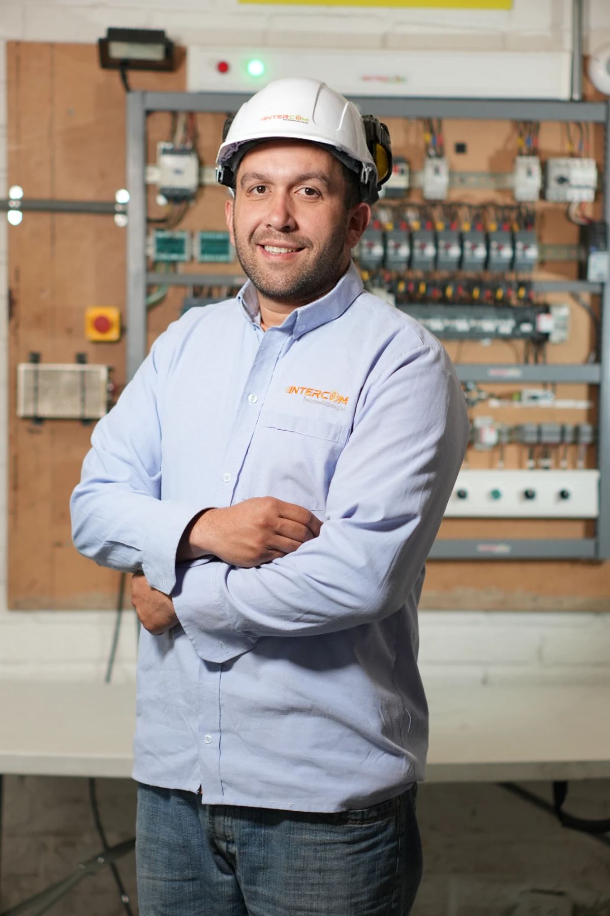 Técnico de INTERCOM TC sonriendo frente a un tablero de control